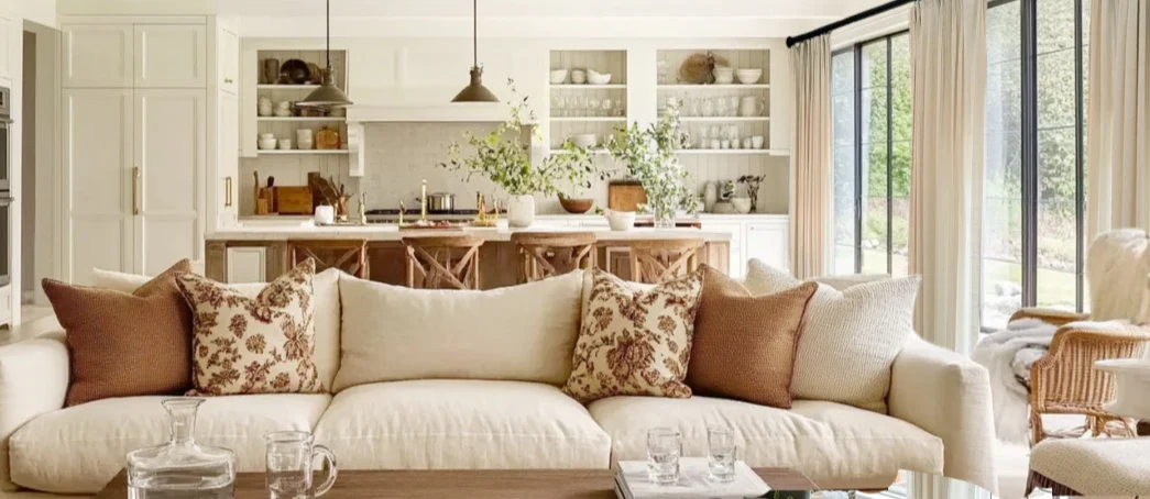 Cozy living room with arched windows, linen curtains, cream sofas, wooden table, and minimalist decor in cotton tones. Bright and inviting ambiance.