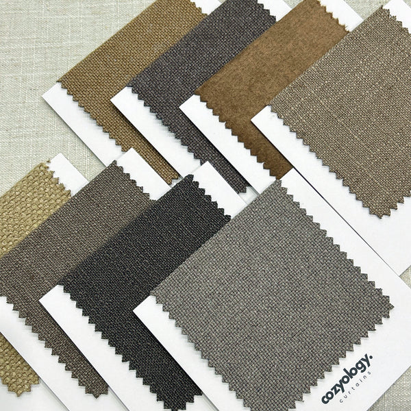 Fabric samples in earthy color tones from Cozyology, offering a variety of neutral shades for curtains and upholstery.