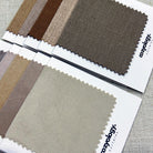 Fabric samples in earthy color tones from Cozyology, offering a variety of neutral shades for curtains and upholstery.
