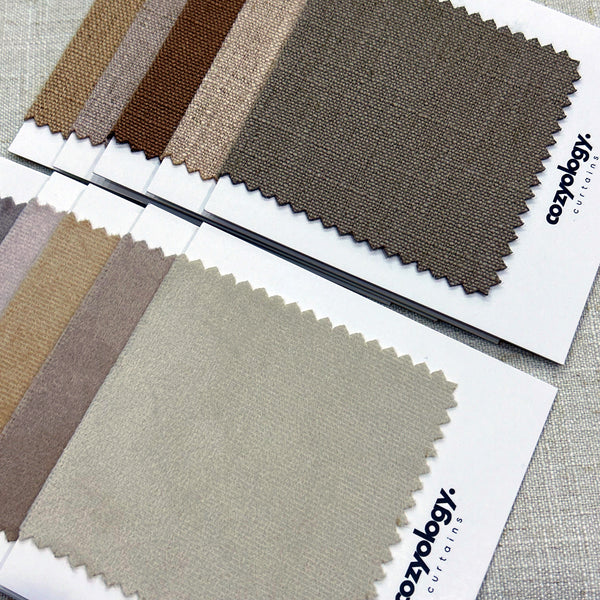 Fabric samples in earthy color tones from Cozyology, offering a variety of neutral shades for curtains and upholstery.